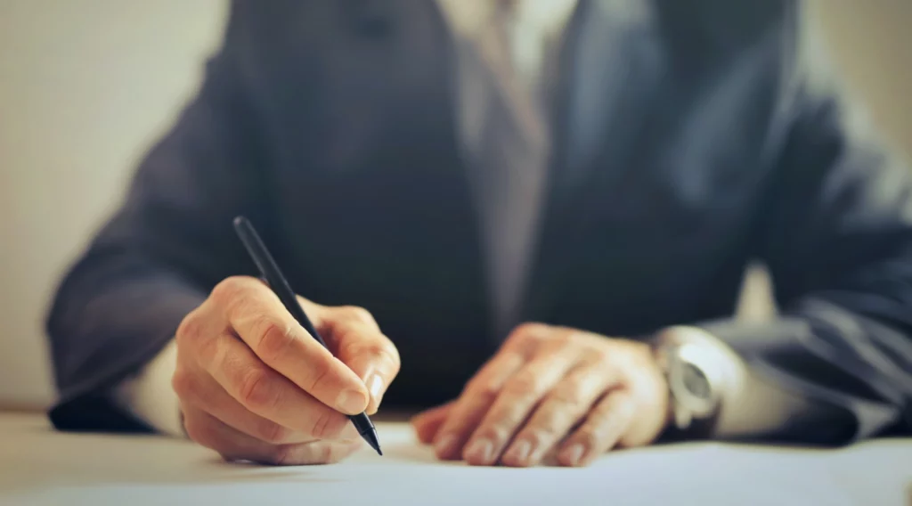 Cropped businessman figure holding a pen and writing